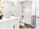 Bright bathroom featuring a vanity with a sink and a shower and tub combo with a purple-striped shower curtain at 1004 Gold Cir, Mebane, NC 27302