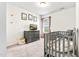 Cozy Bedroom showcasing a gray dresser, a crib with stuffed animals, soft carpet, and framed pictures on the wall at 1004 Gold Cir, Mebane, NC 27302