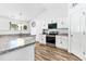 Bright kitchen with white cabinets, modern appliances, and stylish flooring at 1004 Gold Cir, Mebane, NC 27302