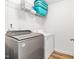 Functional laundry room equipped with a modern washer and dryer, shelving for storage, and wood-look flooring at 1004 Gold Cir, Mebane, NC 27302