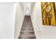 Carpeted staircase with white railing and decorative wall art, leading to the upper level of the home at 1004 Gold Cir, Mebane, NC 27302