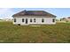 Back of house with solar panels, a small patio, and a spacious grassy yard at 105 Seminole Fields Dr, Broadway, NC 27505
