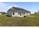Back of house with solar panels, a small patio, and a spacious grassy yard at 105 Seminole Fields Dr, Broadway, NC 27505