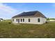 Back of house with solar panels, a small patio, and a spacious grassy yard at 105 Seminole Fields Dr, Broadway, NC 27505