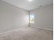 A minimalist bedroom featuring neutral carpet and a large double window, allowing for ample natural light at 105 Seminole Fields Dr, Broadway, NC 27505