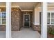 Covered front porch features brick columns and a welcoming front door at 105 Seminole Fields Dr, Broadway, NC 27505