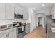 Charming kitchen features gray cabinets, stainless steel appliances, and granite countertops at 105 Seminole Fields Dr, Broadway, NC 27505