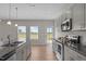 Bright kitchen features stainless steel appliances, gray cabinets, granite countertops, and backyard access at 105 Seminole Fields Dr, Broadway, NC 27505