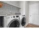 Cozy laundry room featuring a full-size washer and dryer, storage shelf, and stylish wallpaper at 105 Seminole Fields Dr, Broadway, NC 27505
