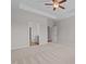 Open main bedroom with carpet, ceiling fan, tray ceilings, and access to the bathroom at 105 Seminole Fields Dr, Broadway, NC 27505
