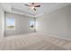 Spacious main bedroom featuring a tray ceiling, carpeted floors, two windows, and a ceiling fan at 105 Seminole Fields Dr, Broadway, NC 27505