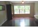 Bedroom with hardwood floors, a built-in cabinet, and a large window overlooking the backyard at 106 N Duelling Oaks Dr, Chapel Hill, NC 27517