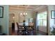 Elegant dining room with chandelier, hardwood floors, and a window with light-blue curtains at 106 N Duelling Oaks Dr, Chapel Hill, NC 27517