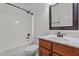 Bathroom features a shower over tub, white tiling, stylish mirror and a wooden vanity at 109 Rustler Rd, Louisburg, NC 27549