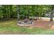 Backyard fire pit area with three Adirondack chairs surrounded by a border of stones at 109 Rustler Rd, Louisburg, NC 27549