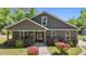 Attractive home with a welcoming front porch and beautifully landscaped garden with colorful shrubs at 109 Rustler Rd, Louisburg, NC 27549