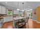 Bright kitchen with hardwood floors, white cabinets, an island with barstool seating and view of the living room at 109 Rustler Rd, Louisburg, NC 27549