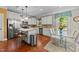 Well-lit kitchen featuring hardwood floors, stainless steel appliances, white cabinets, and a glass top dining table at 109 Rustler Rd, Louisburg, NC 27549