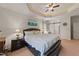 This bedroom features a ceiling fan, a sliding barn door and an upholstered bed with white linens at 109 Rustler Rd, Louisburg, NC 27549