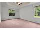 Spacious main bedroom with a decorative tray ceiling, ceiling fan, and two large windows at 109 Rustler Rd, Louisburg, NC 27549