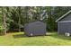 View of gray shed located in the backyard with lush green lawn and trees at 109 Rustler Rd, Louisburg, NC 27549