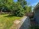 Lush backyard with a picnic table in a partially shaded area, wood fence, and a gravel path at 1100 Chester St, Durham, NC 27701