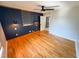 Bedroom with wood floors, ceiling fan, accent wall, and nearby laundry closet at 1100 Chester St, Durham, NC 27701