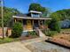 Charming home showcasing a vivid yellow door, complemented by a welcoming wooden porch and appealing blue siding at 1100 Chester St, Durham, NC 27701
