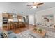 Spacious living room with hardwood floors, ceiling fan, and kitchen with island seating at 115 Moss Creek Pl, Fuquay Varina, NC 27526