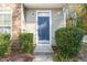 Close-up of a blue front door framed by lush greenery and stone accents at 11700 Coppergate Dr # 100, Raleigh, NC 27614