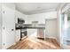 Modern kitchen has stainless steel appliances and white cabinets with outdoor access at 11700 Coppergate Dr # 100, Raleigh, NC 27614