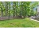Large, lush backyard featuring mature trees, a wooden fence, and a swing hanging from a tree branch at 11944 Appaloosa E, Raleigh, NC 27613