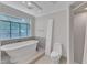 Bright bathroom featuring a soaking tub under a large grid window and a tiled walk-in shower at 11944 Appaloosa E, Raleigh, NC 27613