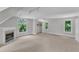 Carpeted room with a fireplace and three windows bringing in natural light at 11944 Appaloosa E, Raleigh, NC 27613