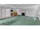 Spacious bonus room featuring a wet bar, fireplace, and built-in cabinets on top of green carpet at 11944 Appaloosa E, Raleigh, NC 27613