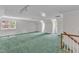Large bonus room with carpet and a staircase with natural light streaming through the windows at 11944 Appaloosa E, Raleigh, NC 27613