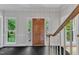 Inviting entryway with a dark tile floor, wooden front door, and views of the landscaped front yard at 11944 Appaloosa E, Raleigh, NC 27613