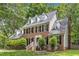 Stately brick home featuring dormer windows, white trim, and lush landscaping surrounded by mature trees at 11944 Appaloosa E, Raleigh, NC 27613