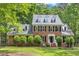 Charming two-story brick home with black shutters, dormer windows, a well-manicured lawn, and mature trees at 11944 Appaloosa E, Raleigh, NC 27613