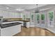 Well-lit kitchen featuring white cabinets, black countertops, a kitchen island, and french doors to a deck at 11944 Appaloosa E, Raleigh, NC 27613