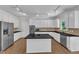 Modern kitchen with white cabinetry, stainless steel appliances, a center island, and dark countertops at 11944 Appaloosa E, Raleigh, NC 27613