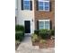Charming townhouse with a black front door, manicured bushes, and a mix of stone and siding exterior at 1304 Cozart St # 109, Durham, NC 27704
