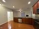 Open-concept kitchen with stainless steel appliances, granite countertops, and wood floors overlooking the living area at 1304 Cozart St # 109, Durham, NC 27704