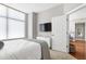 Modern bedroom with a TV, white dresser, and access to the rest of the home at 140 W Franklin St # 706, Chapel Hill, NC 27516