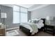 Bedroom with natural light, a large bed, and a modern lamp and end table at 140 W Franklin St # 706, Chapel Hill, NC 27516