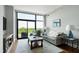 Living room with a large glass doors that lead to a balcony with scenic outdoor views at 140 W Franklin St # 706, Chapel Hill, NC 27516