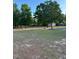 Spacious backyard featuring mature trees, lush green grass, and a storage shed perfect for outdoor activities at 15 Colonial Hills Dr, Lillington, NC 27546