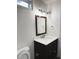Updated bathroom featuring a dark vanity with white countertop, modern fixtures, and a dark framed mirror at 15 Colonial Hills Dr, Lillington, NC 27546