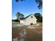 View of the three-car garage and a section of the home's exterior with a well-maintained lawn at 15 Colonial Hills Dr, Lillington, NC 27546