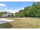 Large backyard with a wooden fence, a concrete patio, and lush green trees at 15 Epping Ct, Durham, NC 27703